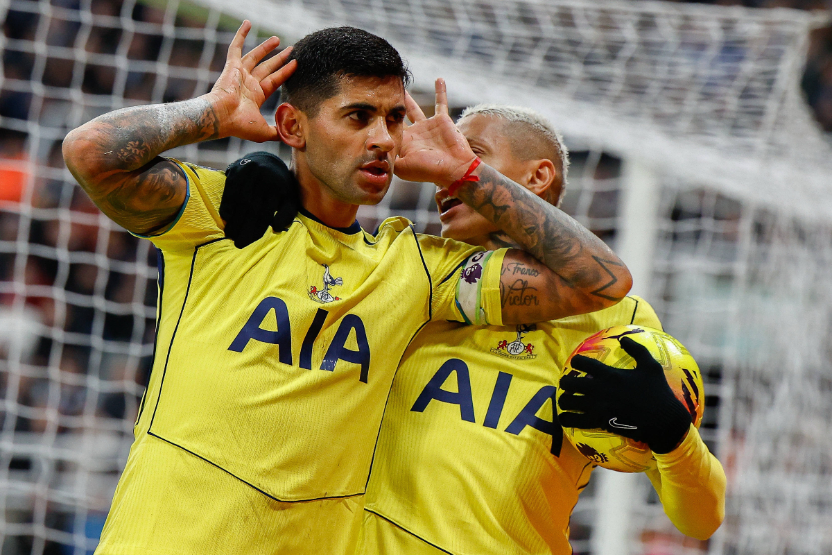 Cristian Romero in the yellow away Spurs jersey celebrating a goal.